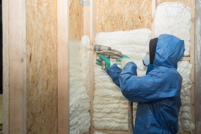 Spray foam insulation application along basement rim joists for air sealing